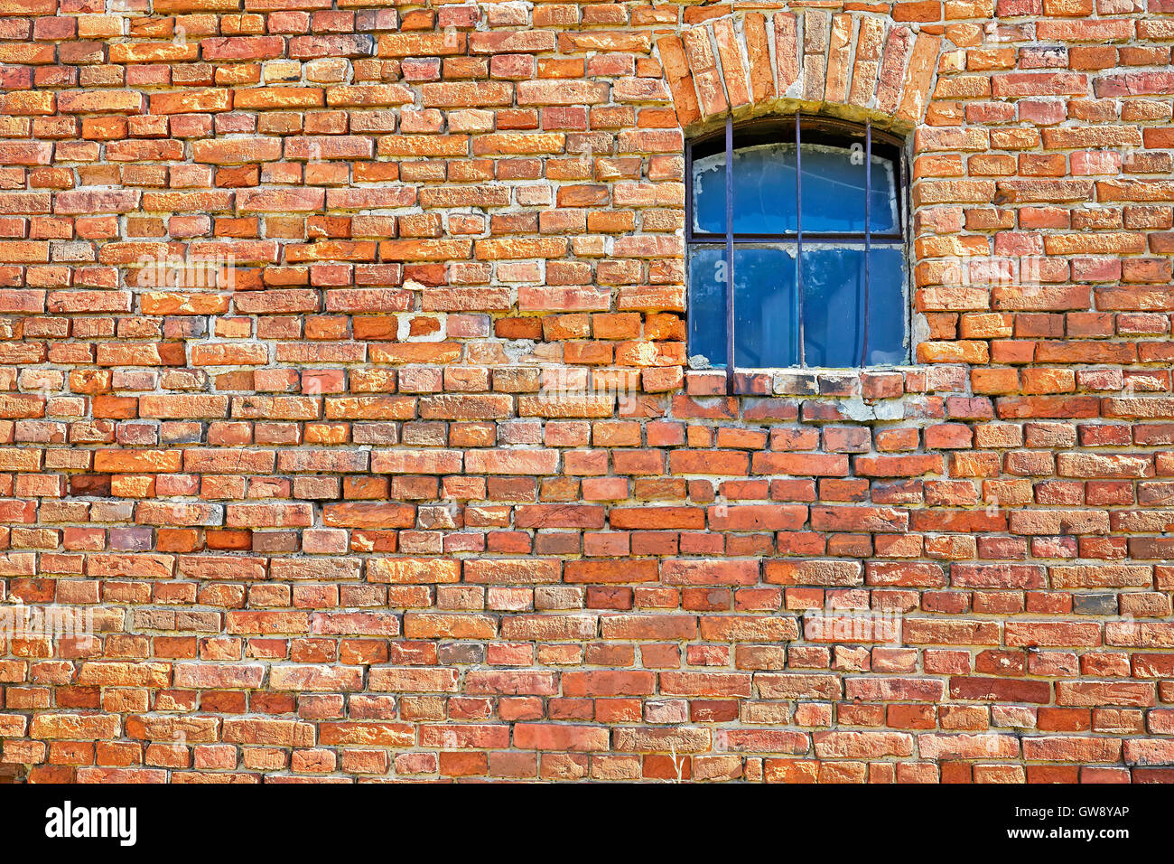 Vieux mur de briques avec une petite fenêtre. Banque D'Images