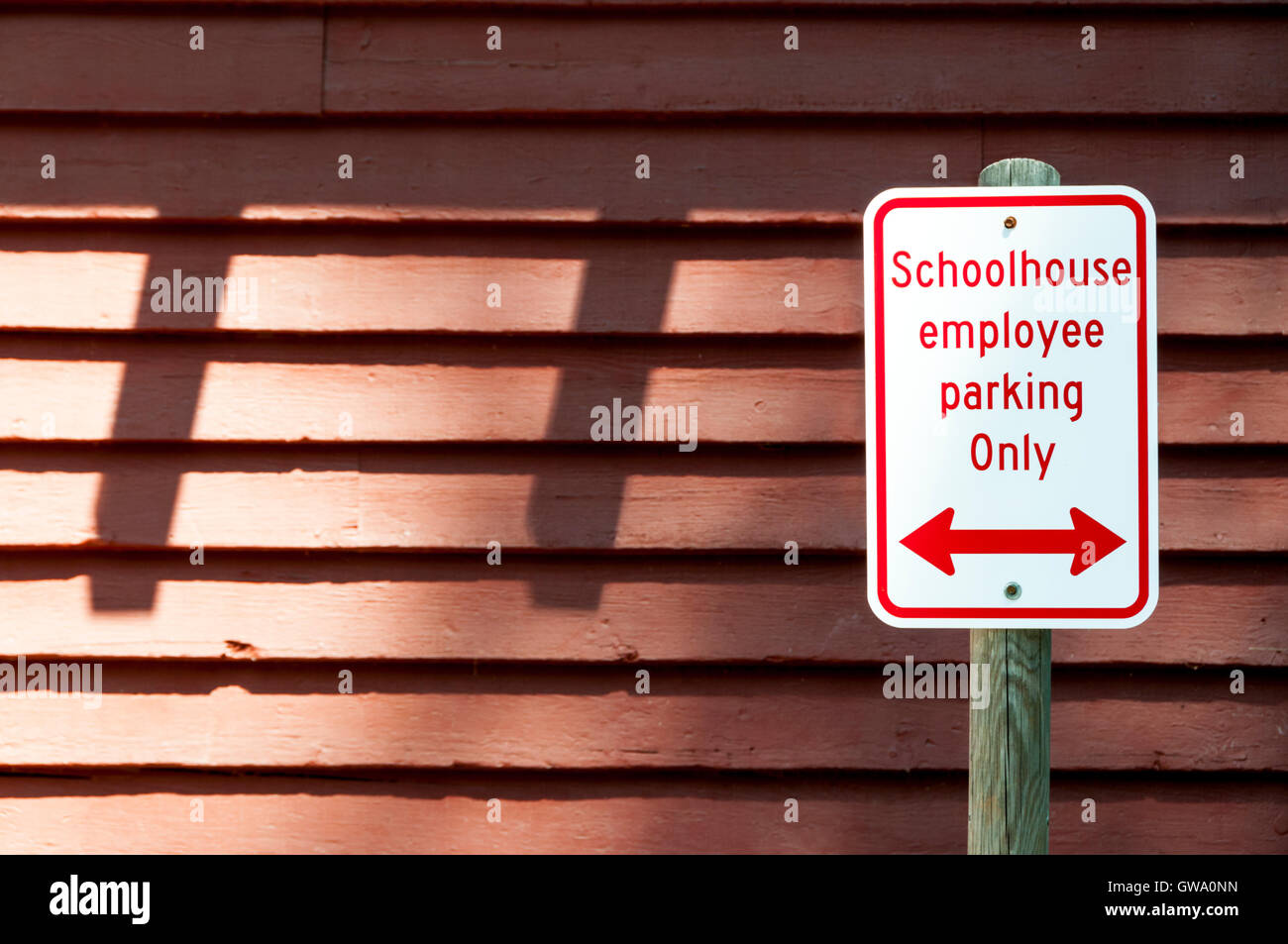 Signe devant woodedn des capacités de stationnement pour les employés de l'école lecture seulement, avec une double flèche. Banque D'Images