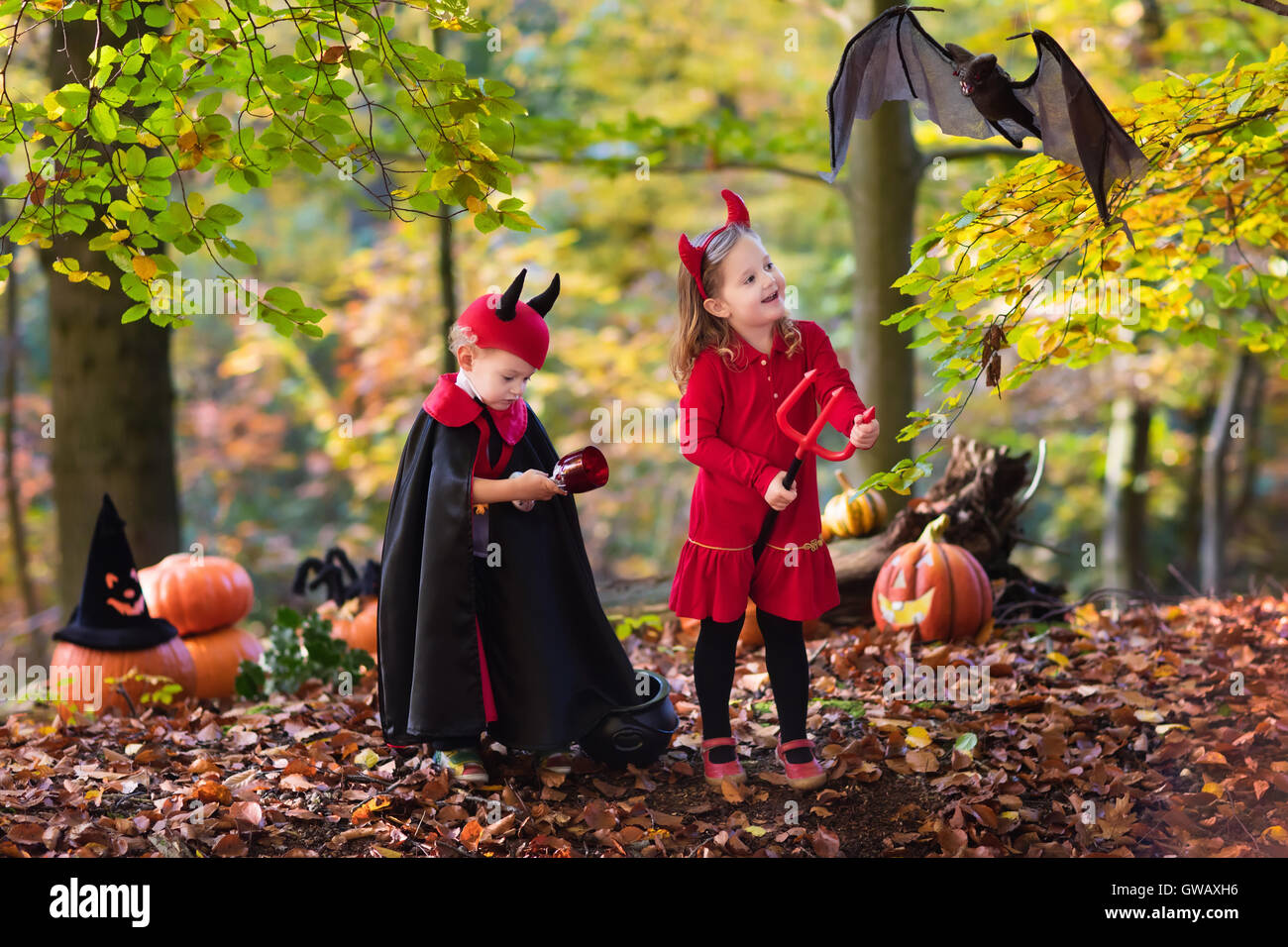 Deux drôles kids wearing devil costume vampire et avec des cornes rouges et trident trick or treating sur Halloween. Banque D'Images