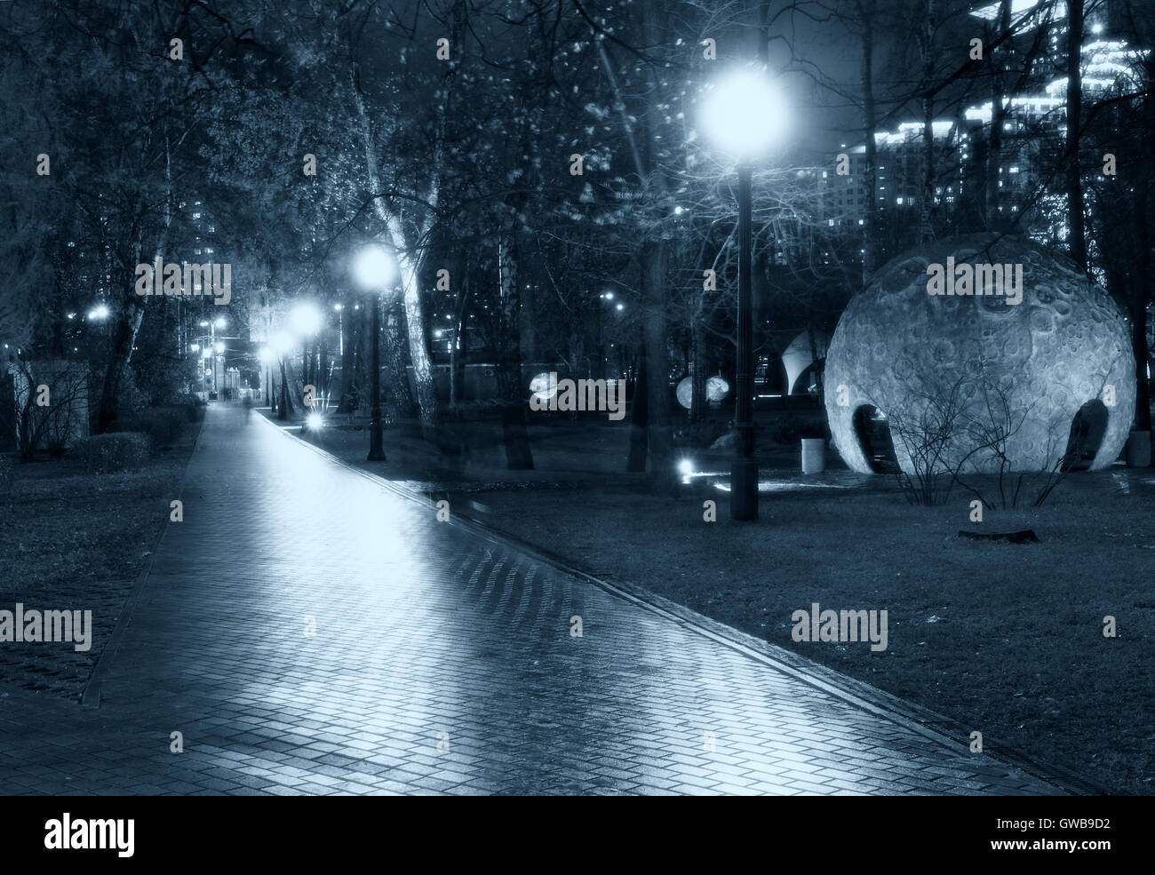 Park nuit pathway : une vue d'une allée allée / / voie dans un parc allumée par lanternes / lampes / streetlight avec arbres Banque D'Images