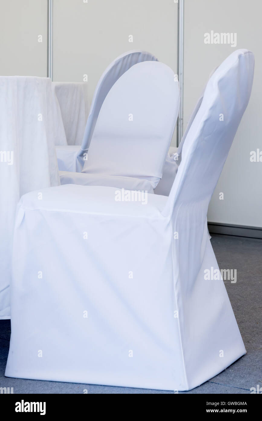 Les chaises avec revêtement en tissu blanc pour les fêtes Banque D'Images