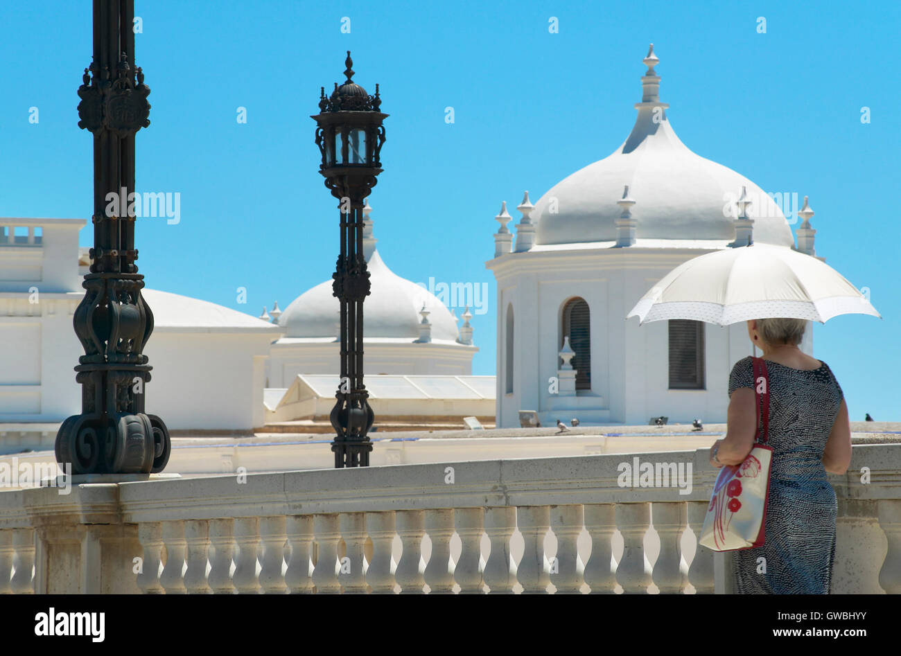 Femme avec parapluie marcher sous le soleil. Cadix, Espagne. L'horizontale Banque D'Images