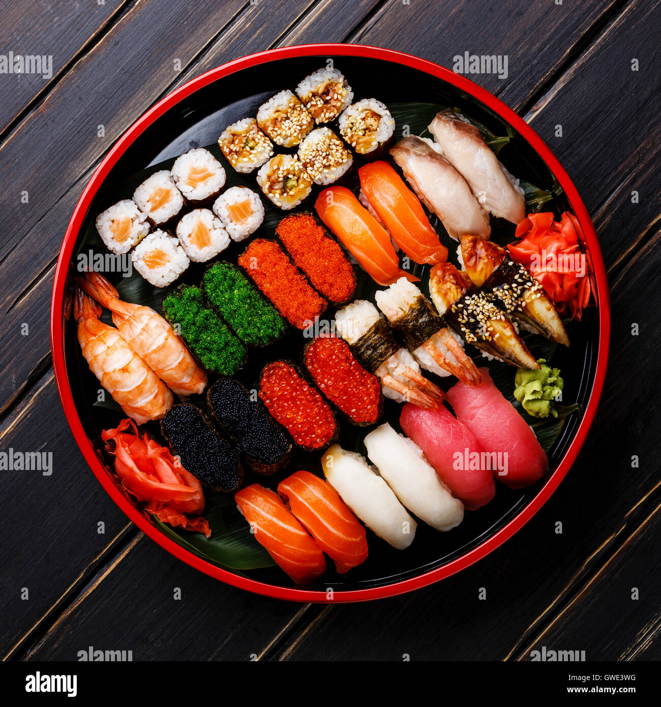 Set de sushis nigiri gunkan, rouleaux et servi dans le Japon traditionnel plaque ronde Sushioke noir Banque D'Images