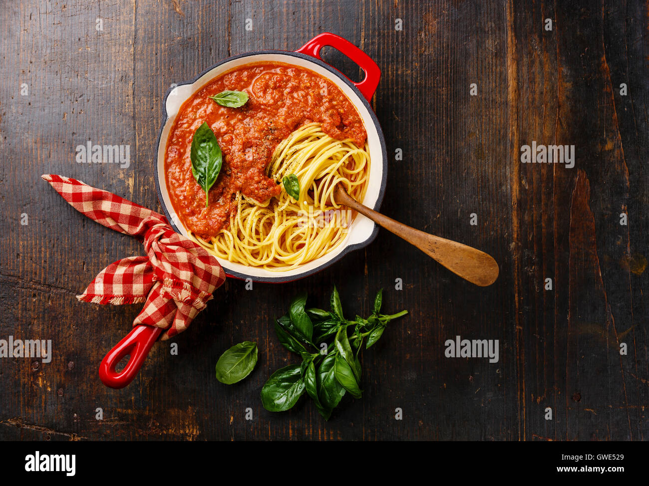 Spaghettis à la bolognaise avec une sauce tomate et basilic dans poêle de fer sur fond de bois Banque D'Images