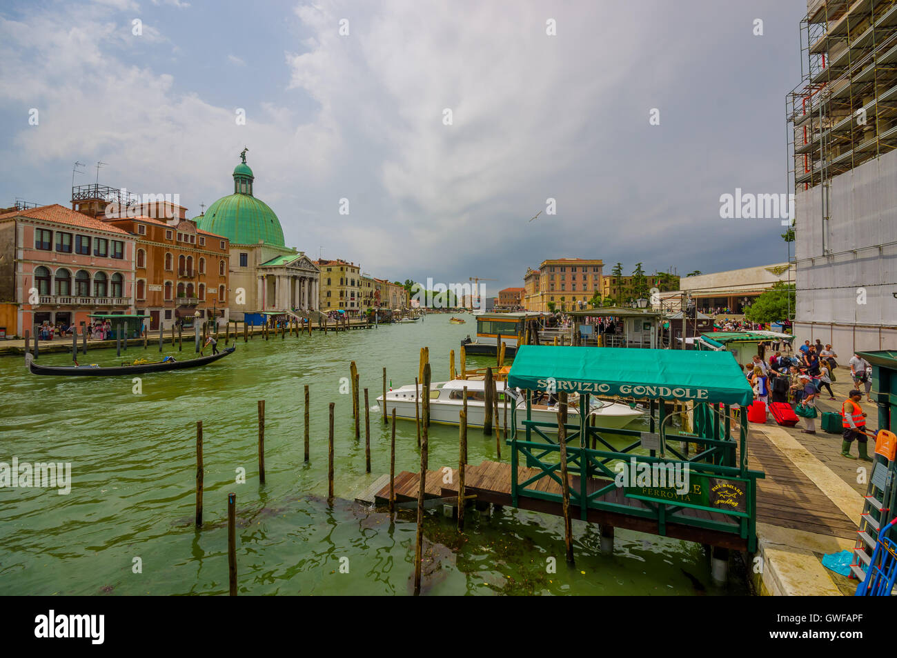 Venise, Italie - le 18 juin 2015 : les touristes d'Goldola dans port canal vénitien, l'eau coule tout autour de la ville. Vue sur le dôme vert Banque D'Images