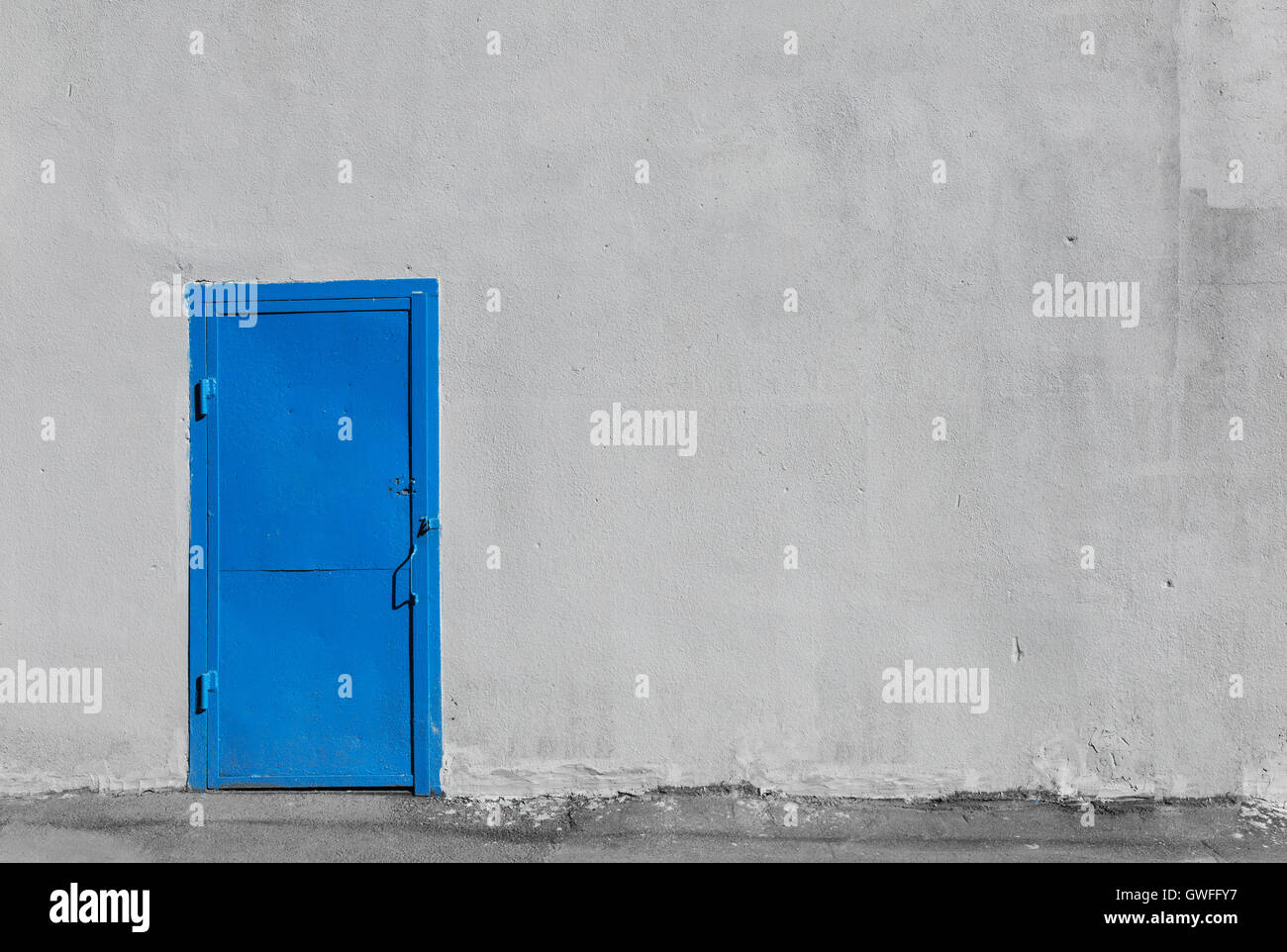 Porte en métal gris bleu sur le mur du bâtiment en stuc Banque D'Images