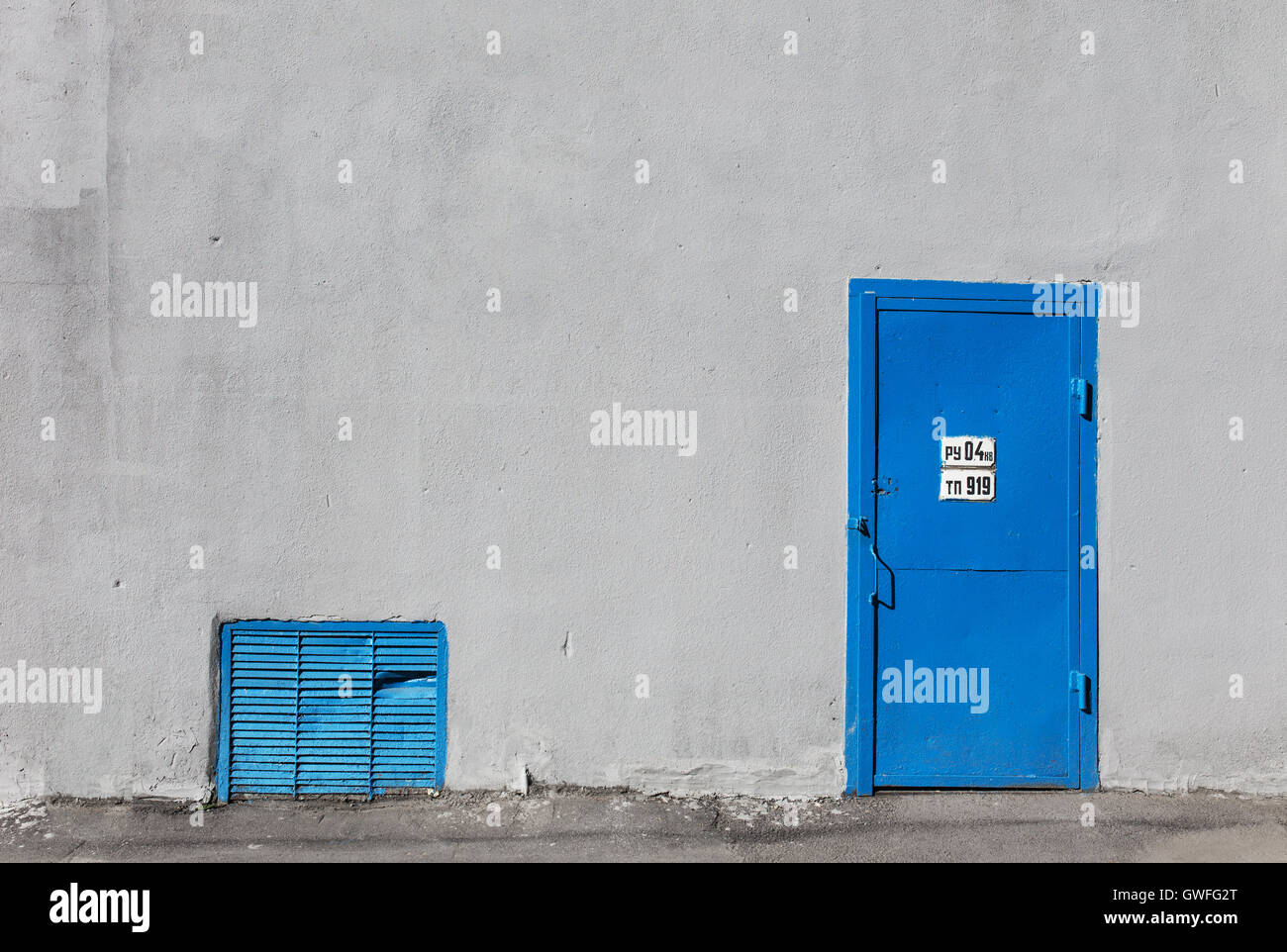 Porte en métal gris bleu sur le mur du bâtiment en stuc Banque D'Images