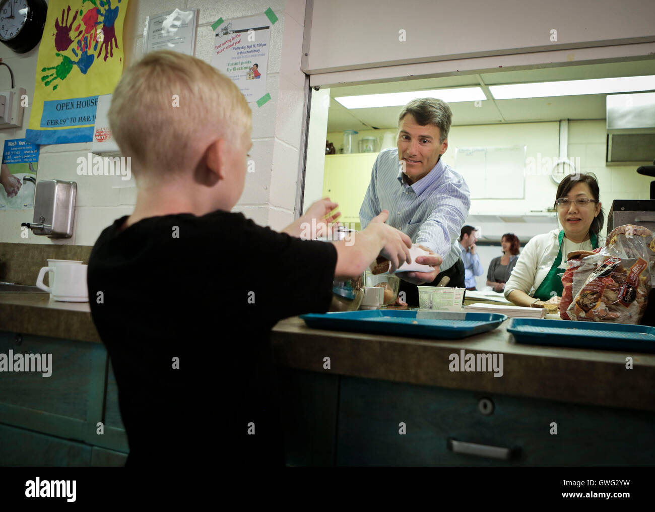 Vancouver, Canada. 13 Sep, 2016. Un enfant reçoit de la nourriture de le maire de Vancouver, Gregor Robertson, à la Strathcona Community Centre à Vancouver, Canada, du 13 septembre 2016. Le maire de Vancouver, Gregor Robertson s'est joint à des bénévoles pour aider à distribuer le petit-déjeuner gratuit pour les enfants de familles à faible revenu. © Liang Sen/Xinhua/Alamy Live News Banque D'Images