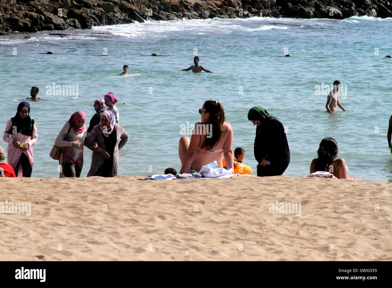 Nahariya, Israël. 13 Sep, 2016. Une femme musulmane portant un hijab se  trouve dans la mer Méditerranée une femme israélienne portant un bikini est  à proximité, à une plage à Nahariya, Israël ©