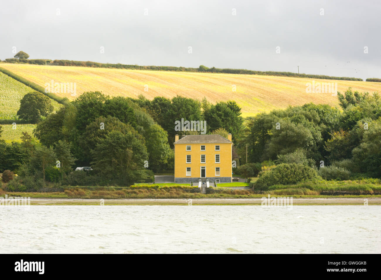 Grande propriété jaune sur les rives de l'estuaire de la rivière Teifi à Cardigan, Pembrokeshire, Pays de Galles, Royaume-Uni. Banque D'Images