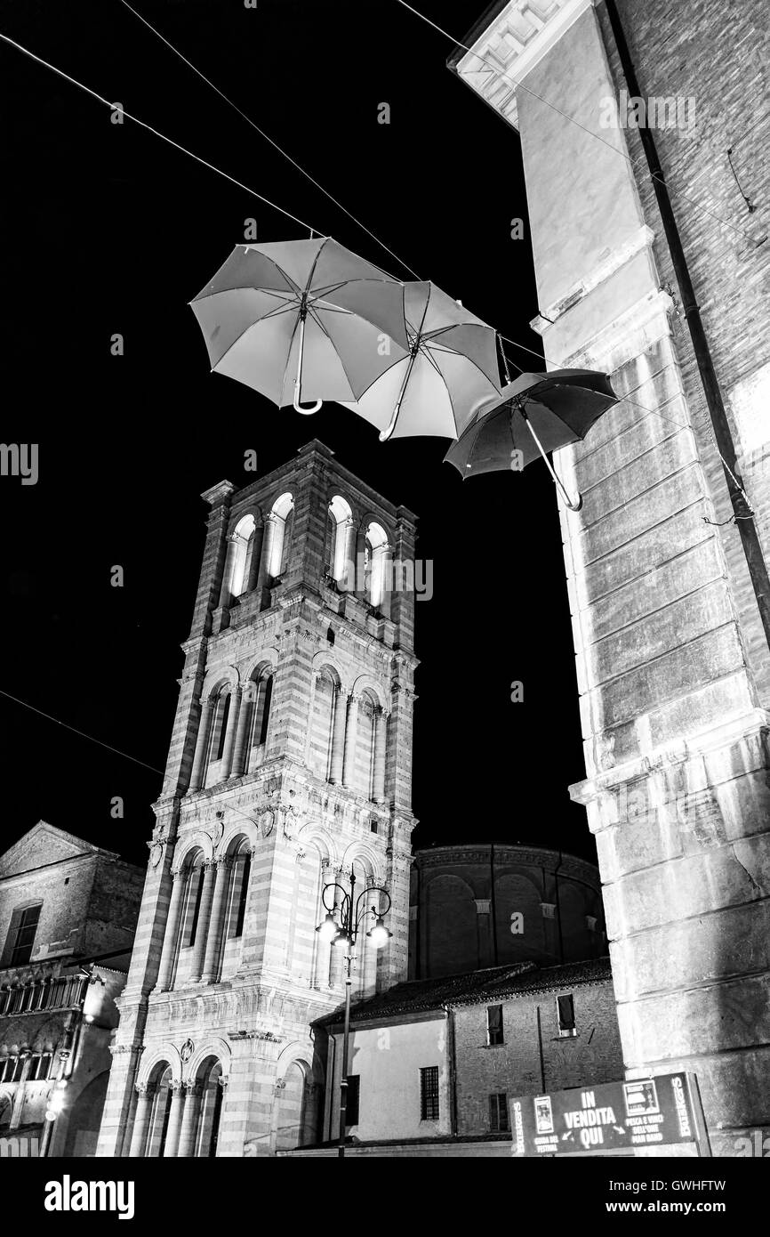 Tour de la Cathédrale de Ferrare et trois parasols suspendu par un fil en noir et blanc Banque D'Images