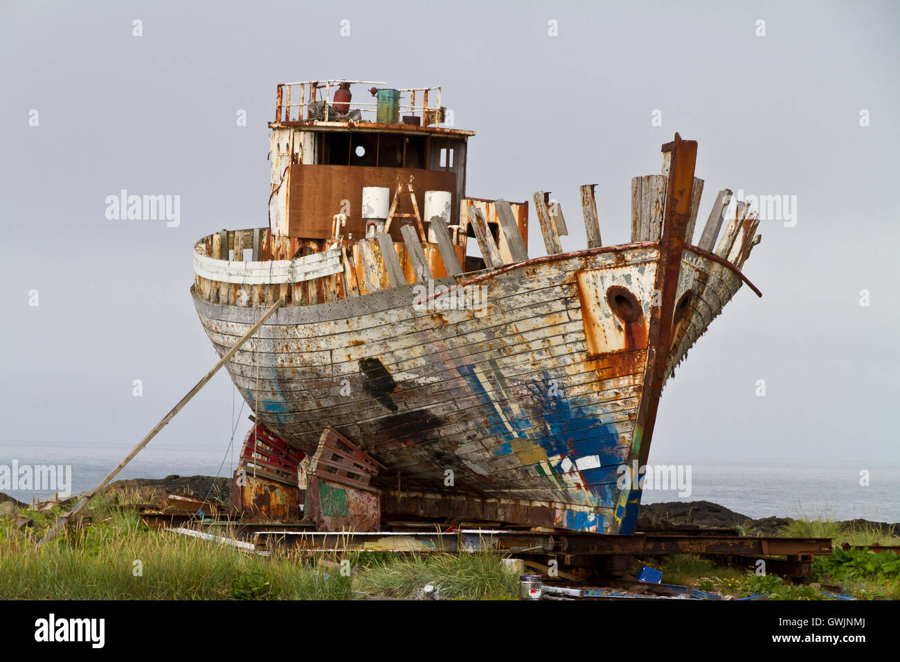 Old rusty chalutier de pêche étant cassée vers le haut sur la rive, bow à l'appareil photo Banque D'Images