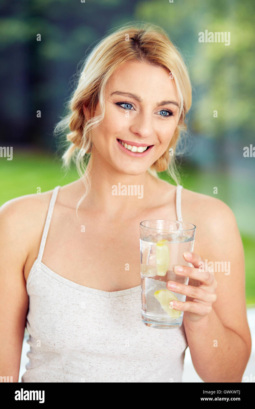Fille de boire dans un verre d'eau glacée au citron Banque D'Images