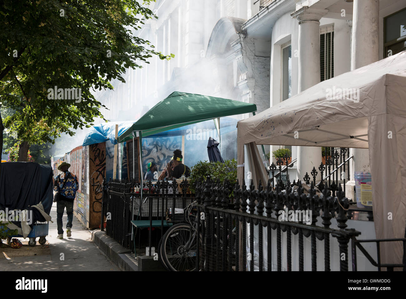 Les résidents de la cuisson et la vente des aliments des Caraïbes à l'extérieur de leur foyer au cours du carnaval de Notting Hill Banque D'Images