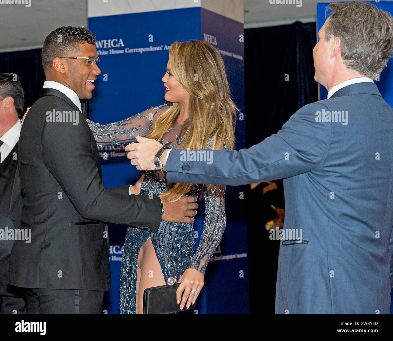 Chrissy Teigen salue des Seattle Seahawks quarterback Russell Wilson qu'ils arrivent sur le tapis rouge pour la Maison Blanche 2015 Dîner annuel de l'Association des correspondants à l'hôtel Hilton de Washington, le samedi 25 avril 2015. Editeur Jason Binn est à ri Banque D'Images