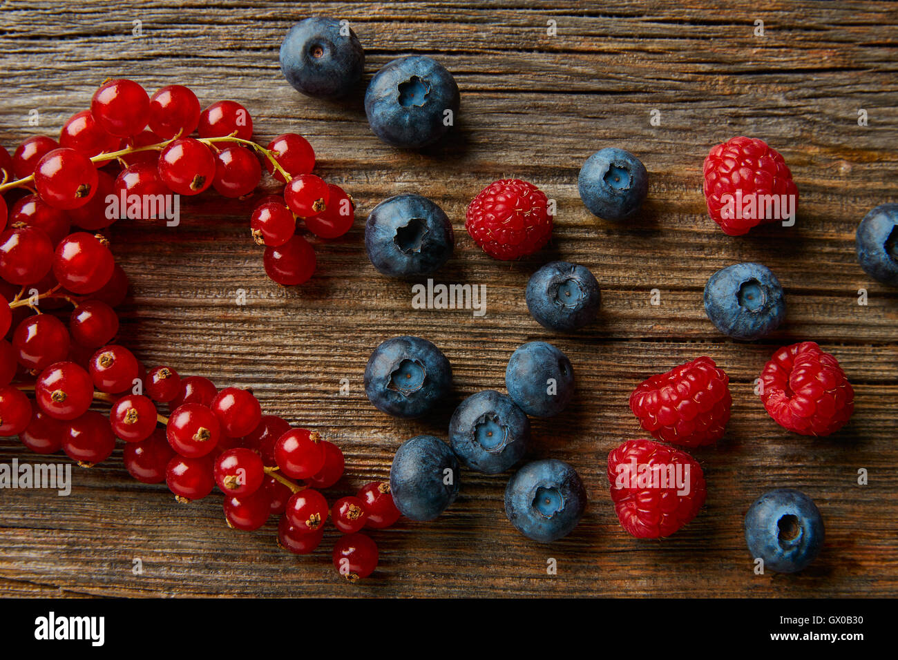Mélange de petits fruits sur planche de bois les bleuets et framboises Groseilles rouges Banque D'Images