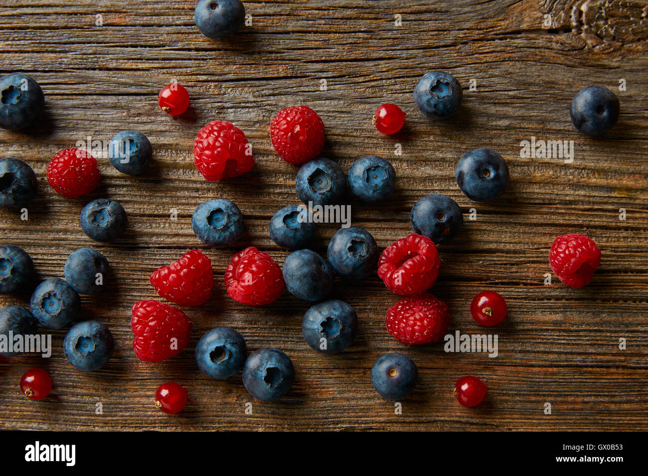 Mélange de petits fruits sur planche de bois les bleuets et framboises Groseilles rouges Banque D'Images