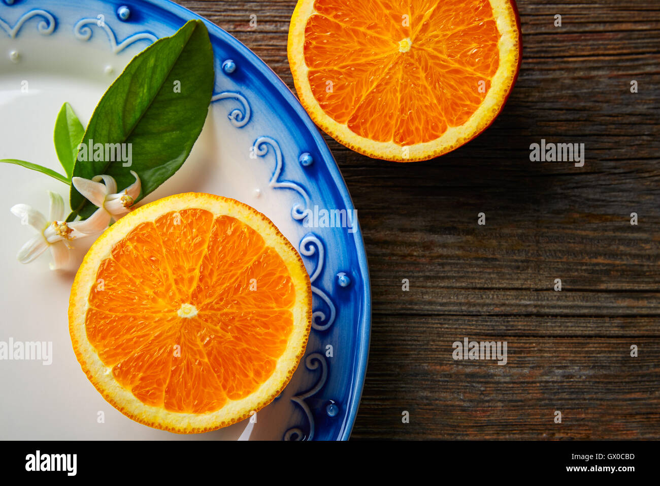 Couper la moitié des fruits orange open orange avec fleur sur table en bois Banque D'Images