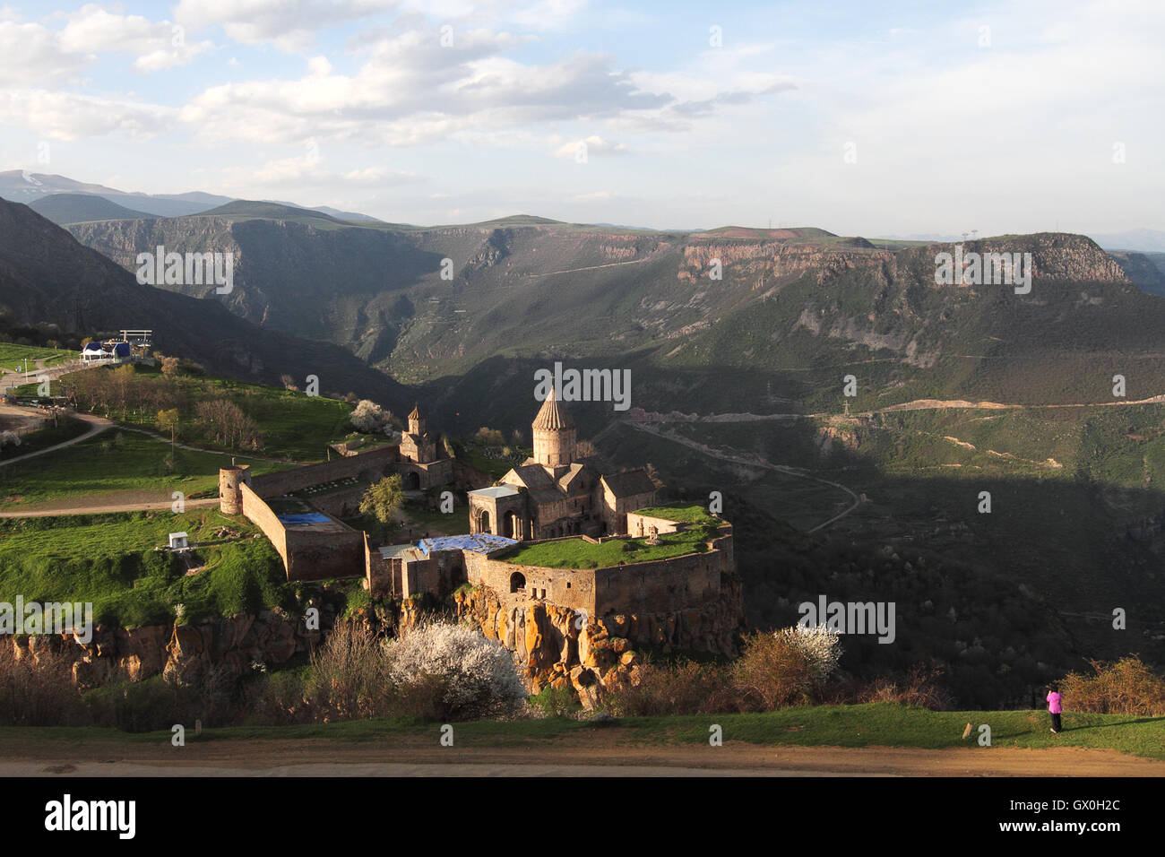 Femme en violet photographier le monastère de Tatev en Arménie. Banque D'Images