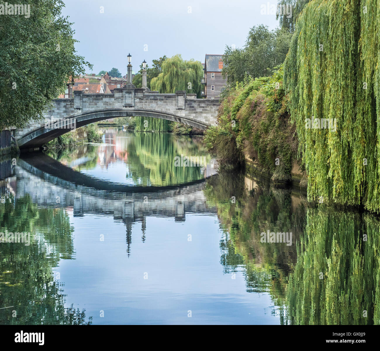 Réflexions d'un vieux pont de pierre et des arbres dans la rivière Wensum, Norwich, Angleterre Banque D'Images