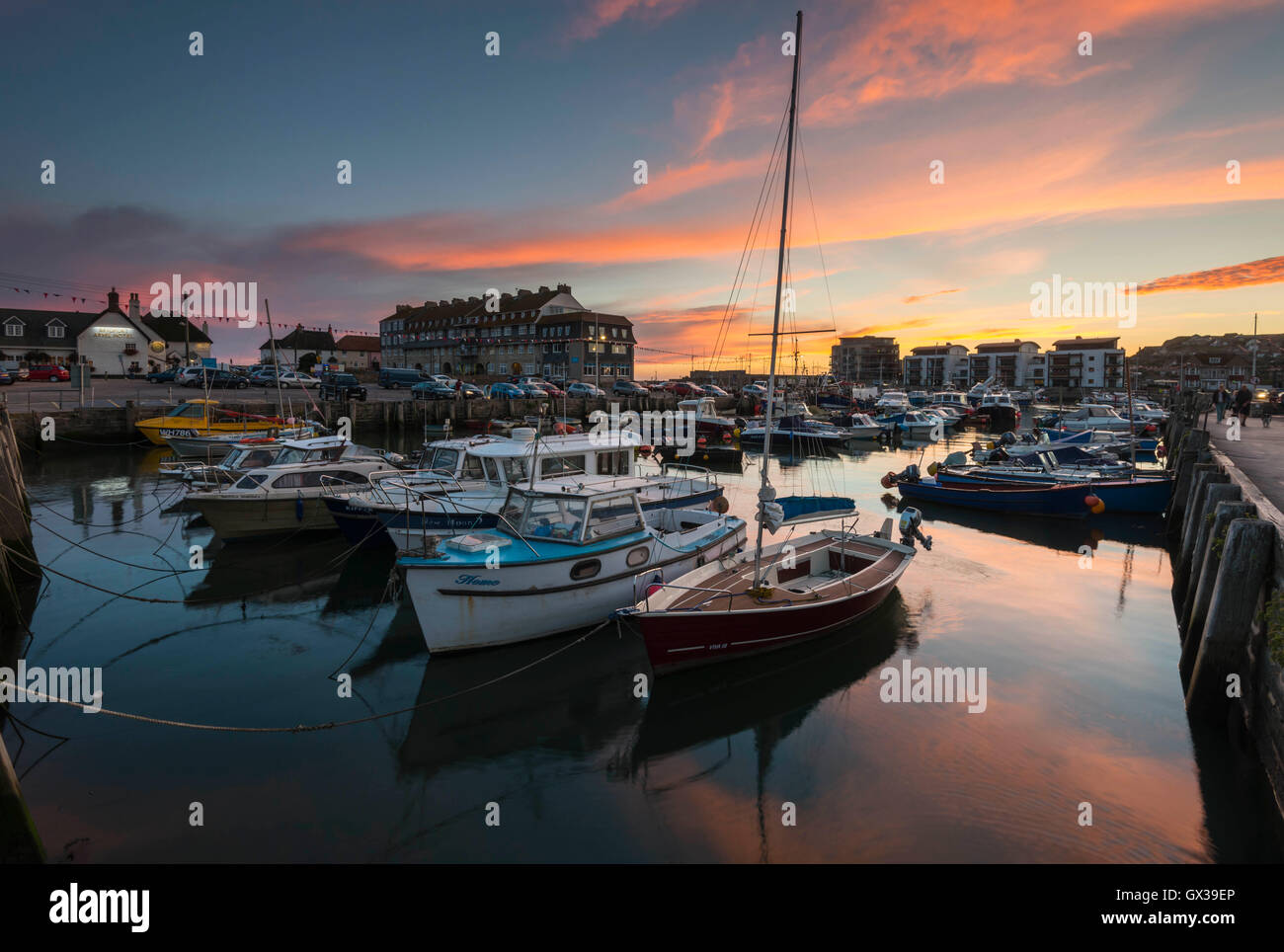 West Bay, Dorset, UK - 14 septembre 2016. Météo britannique. Un magnifique coucher du soleil illuminant les nuages au-dessus de West Bay Harbour dans le Dorset, UK. West Bay est l'un des endroits pour la série ITV Broadchurch. Photo : Graham Hunt/Alamy Live News Banque D'Images