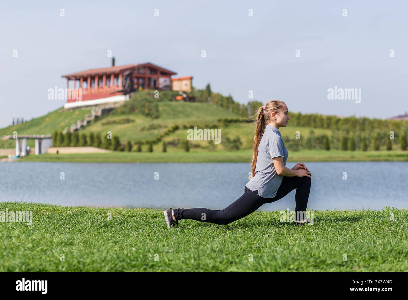 Happy young girl doing stretching exercises en parc d'été Banque D'Images