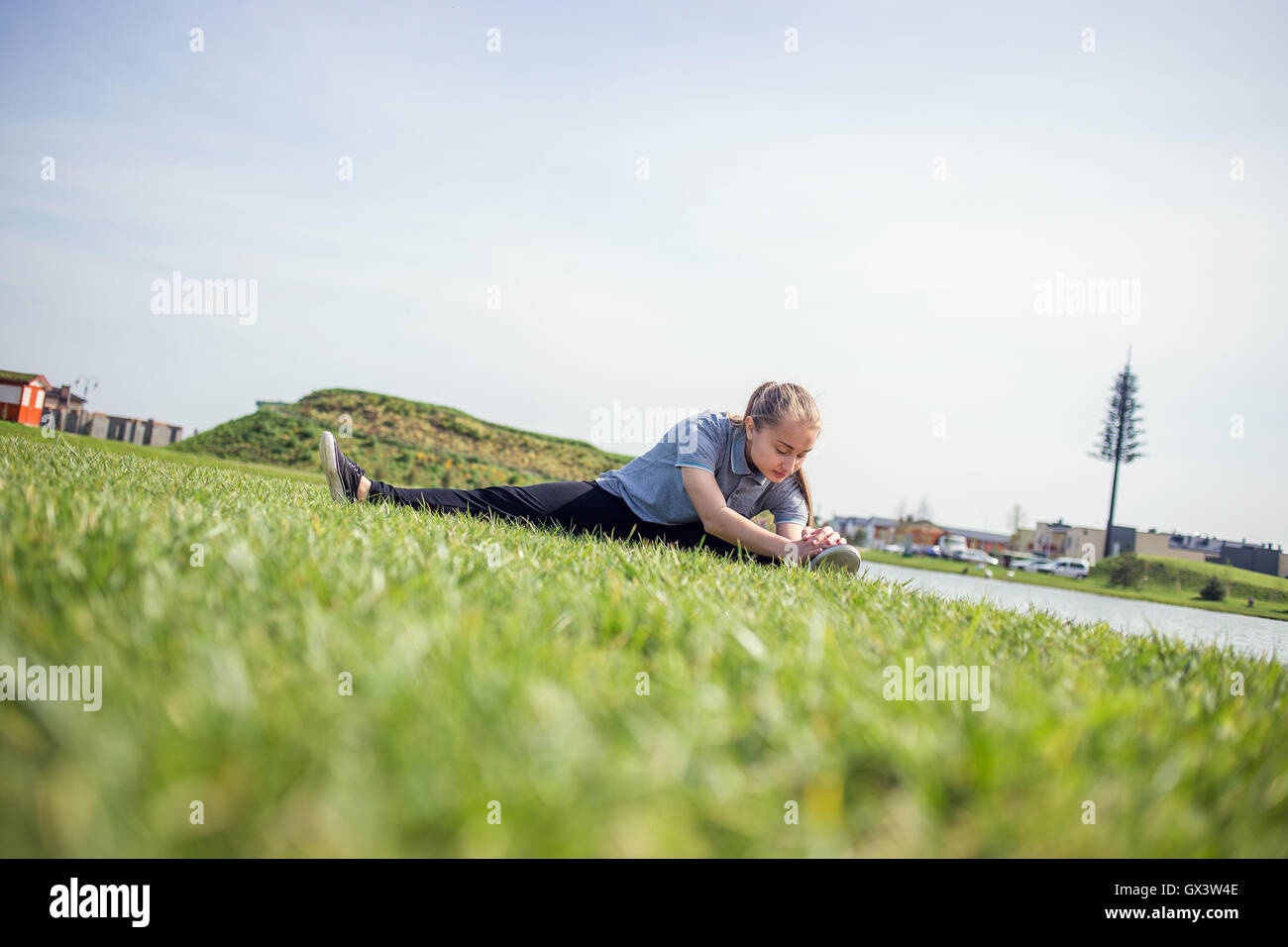 Happy young girl doing stretching exercises en parc d'été Banque D'Images