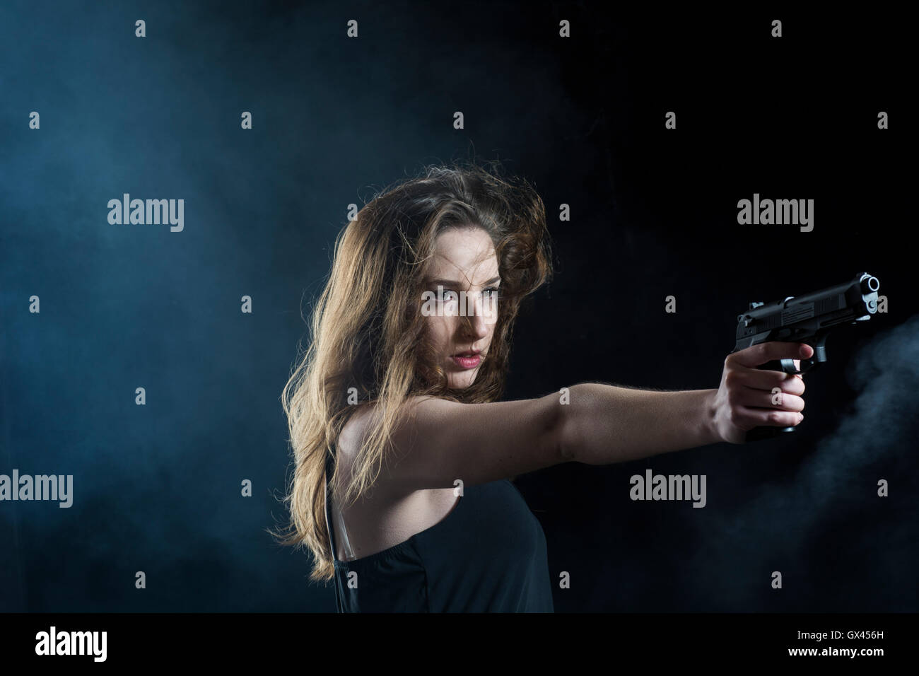 Femme visant une arme à feu Banque D'Images