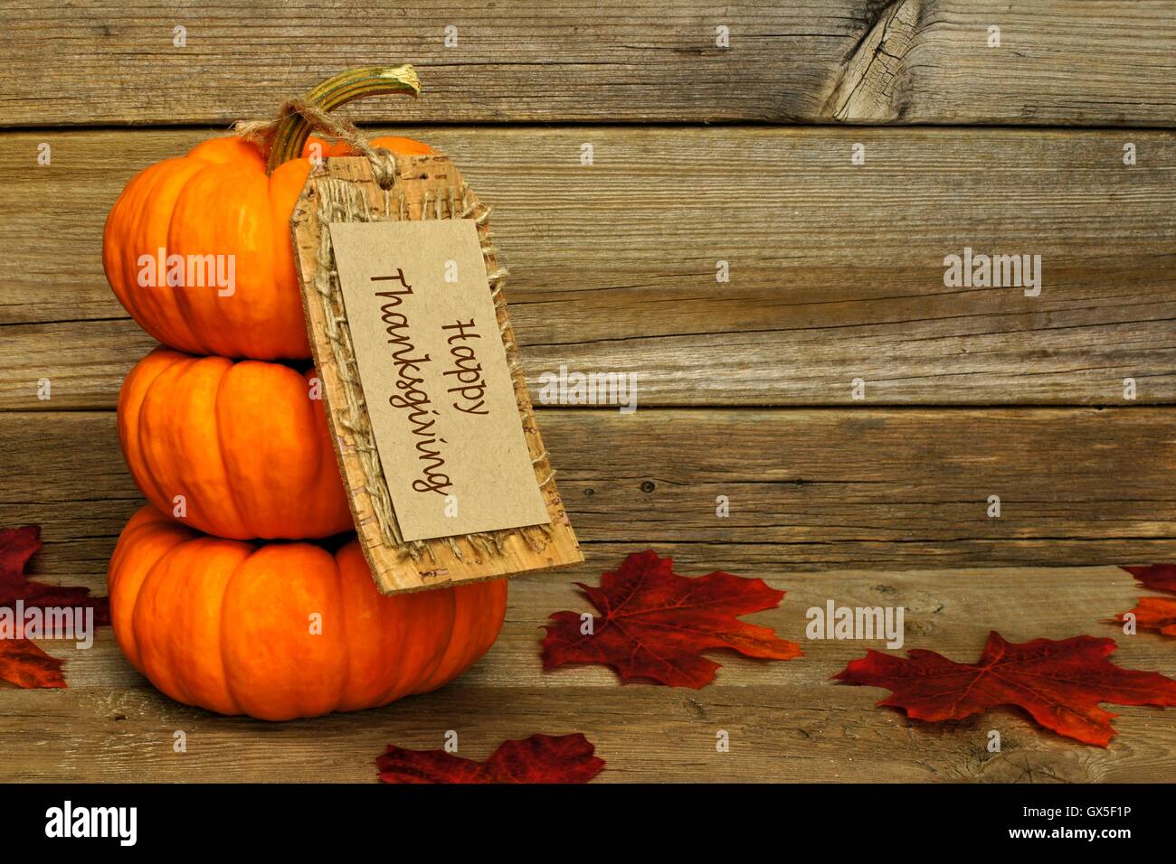 Pile de mini potirons avec happy thanksgiving tag sur un fond de bois Banque D'Images