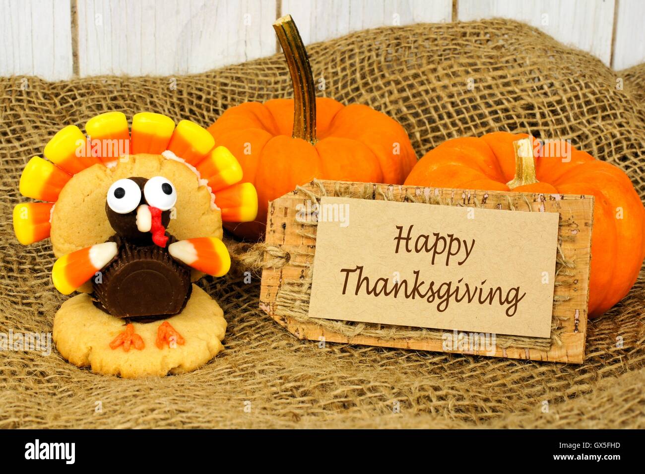 Joyeux thanksgiving tag avec la Turquie et des citrouilles en forme de cookie avec de la toile de jute et bois contexte Banque D'Images