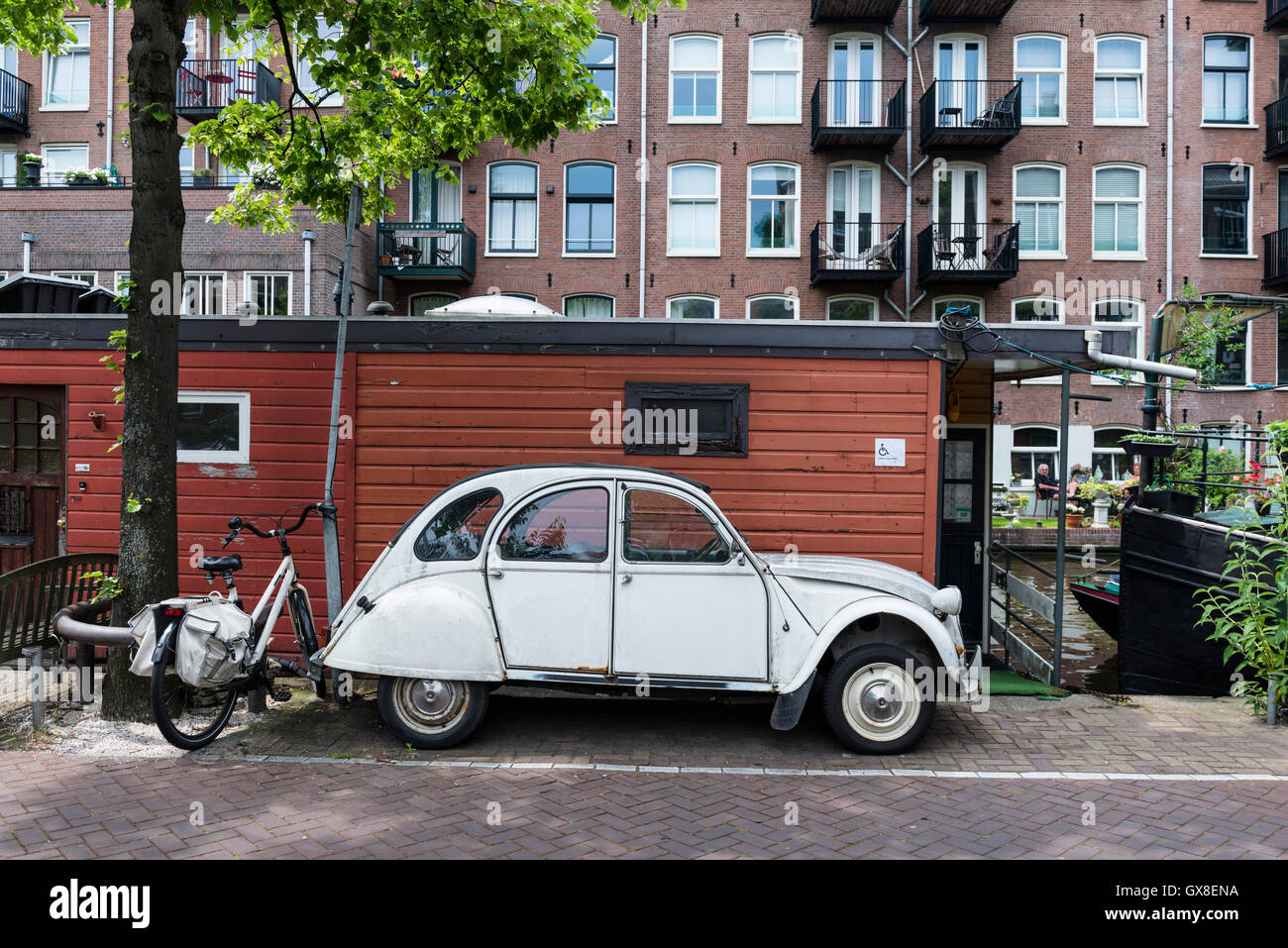 Une Citroën deux chevaux sur le Lijnbaansgracht dans le quartier Jordaan. Bateaux-maison sont la doublure de canal. Banque D'Images