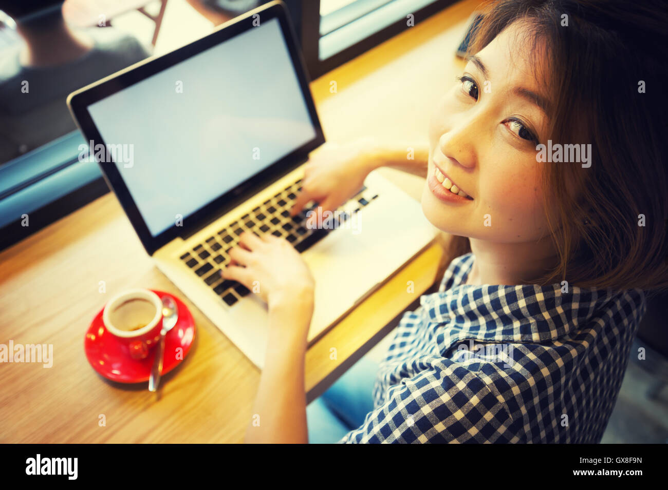 Femme à l'aide d'un ordinateur portable pendant une pause-café, les vacances concept, effet vintage Banque D'Images