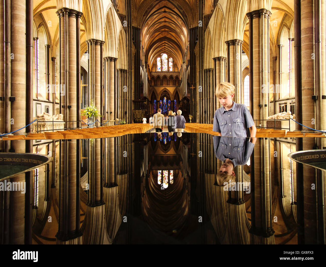 Nef et font de la cathédrale de Salisbury avec un jeune garçon à la police, à Salisbury, Angleterre Banque D'Images