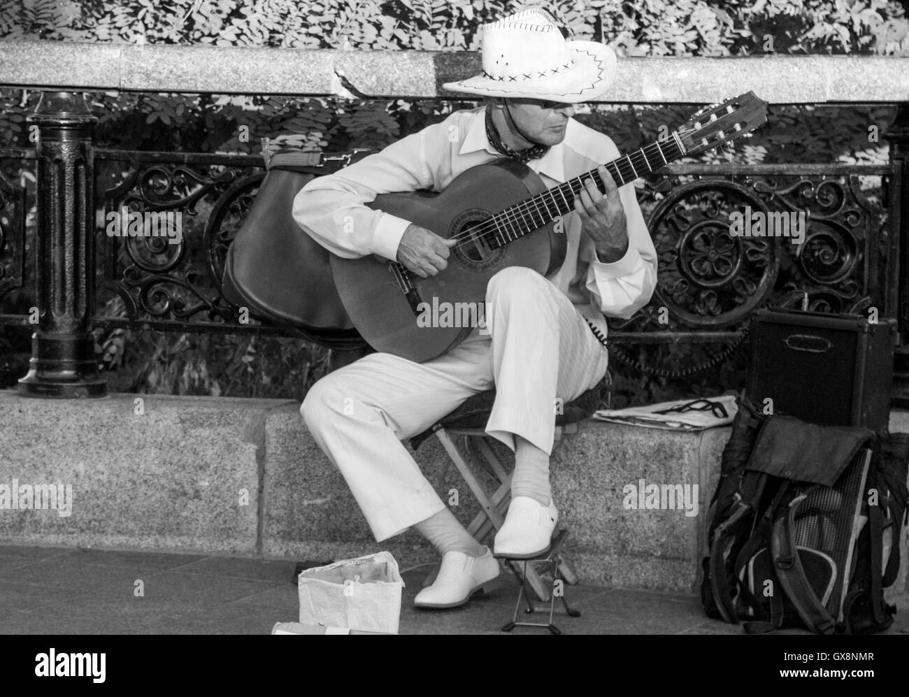 Homme dans un chapeau à large bord qui joue de la guitare dans la rue. Photo en noir et blanc Banque D'Images