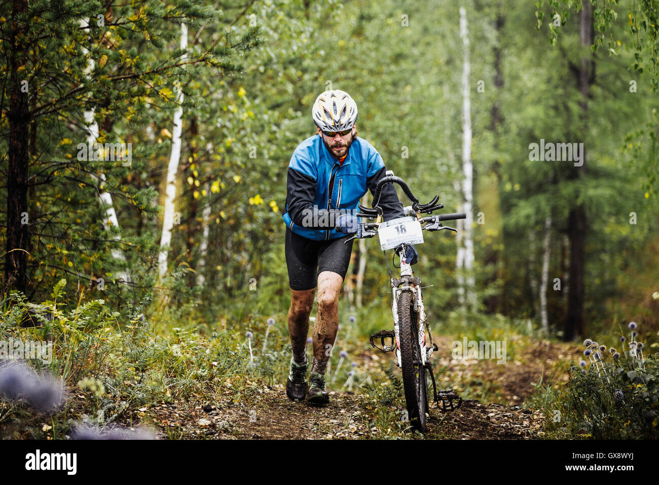 Les jeunes cyclistes en montée dans la forêt au cours de randonnées compétitions régionales sur vélo cross-country Banque D'Images