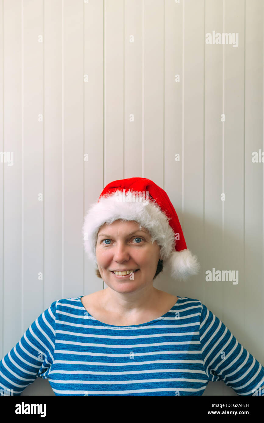 Happy woman with Christmas Santa Claus hat dans la préparation de l'humeur de vacances pour Noël ou le Nouvel An. Banque D'Images