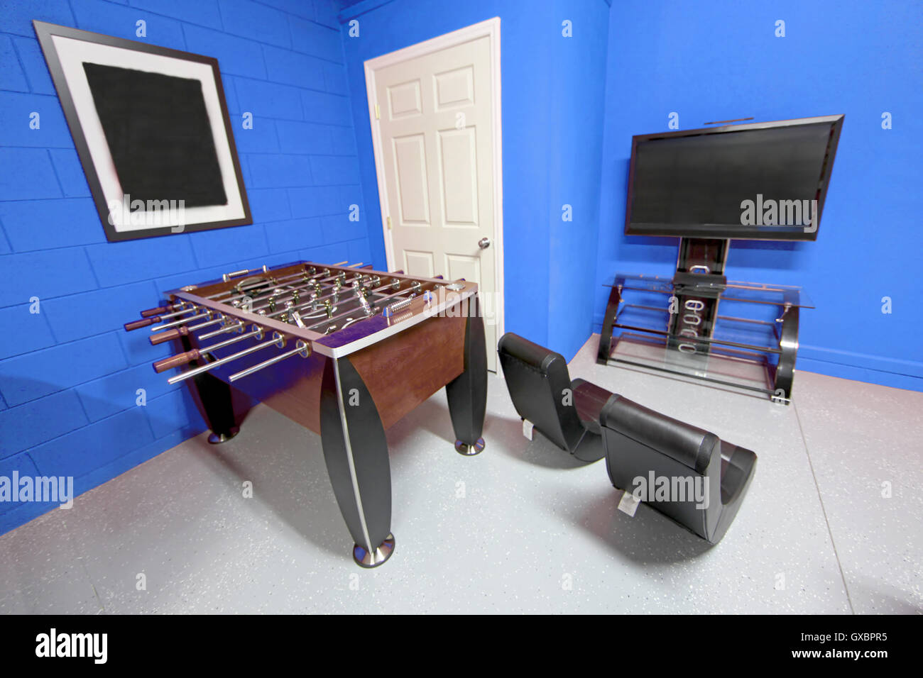 Une salle de jeux avec baby-foot, télévision et des jeux de chaises Banque D'Images