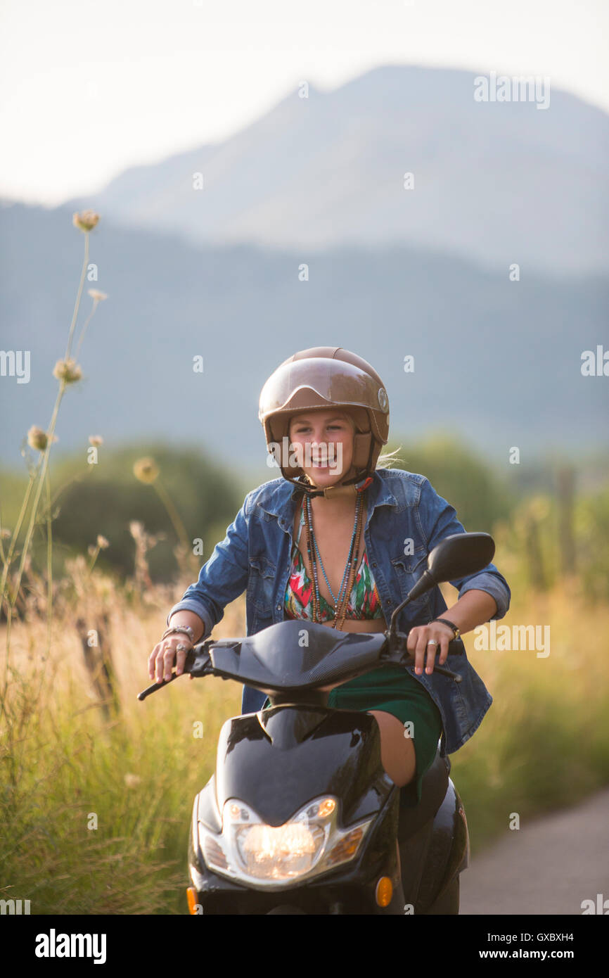 Happy young woman riding moped on rural road, Majorque, Espagne Banque D'Images