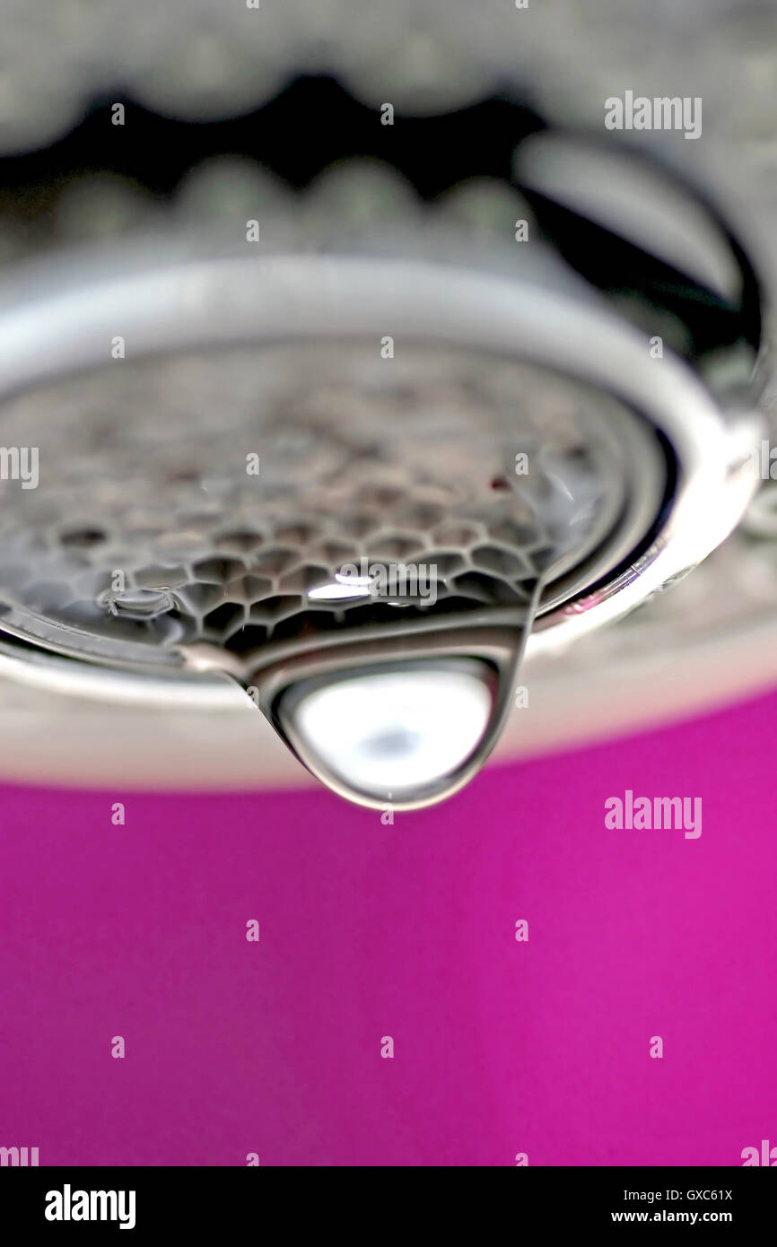 Une macro d'un robinet robinet blanc / rose dégoulinant d'arrière-plan. Banque D'Images
