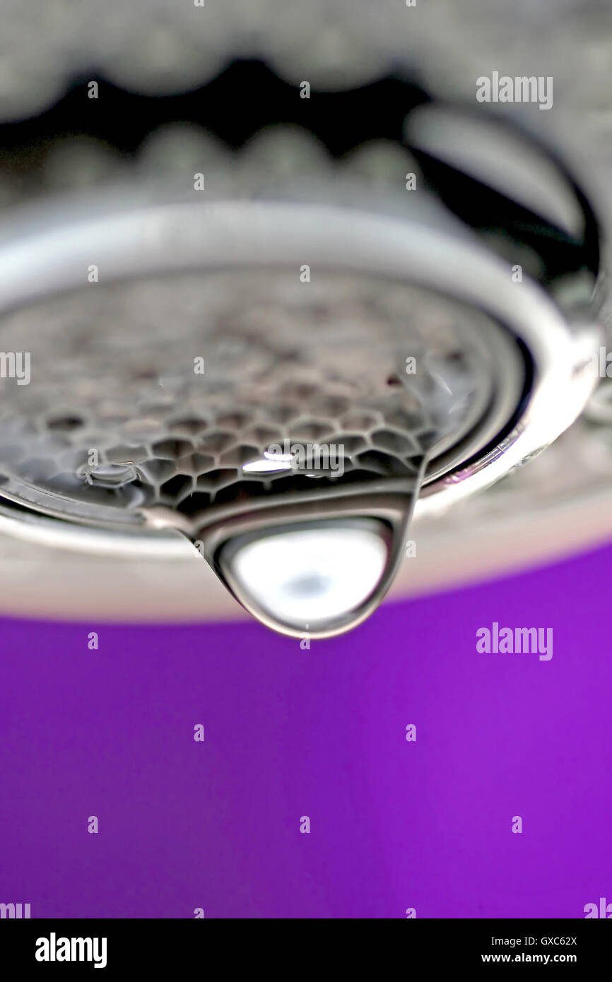 Une macro d'un robinet robinet blanc / dégoulinant de fond violet. Banque D'Images