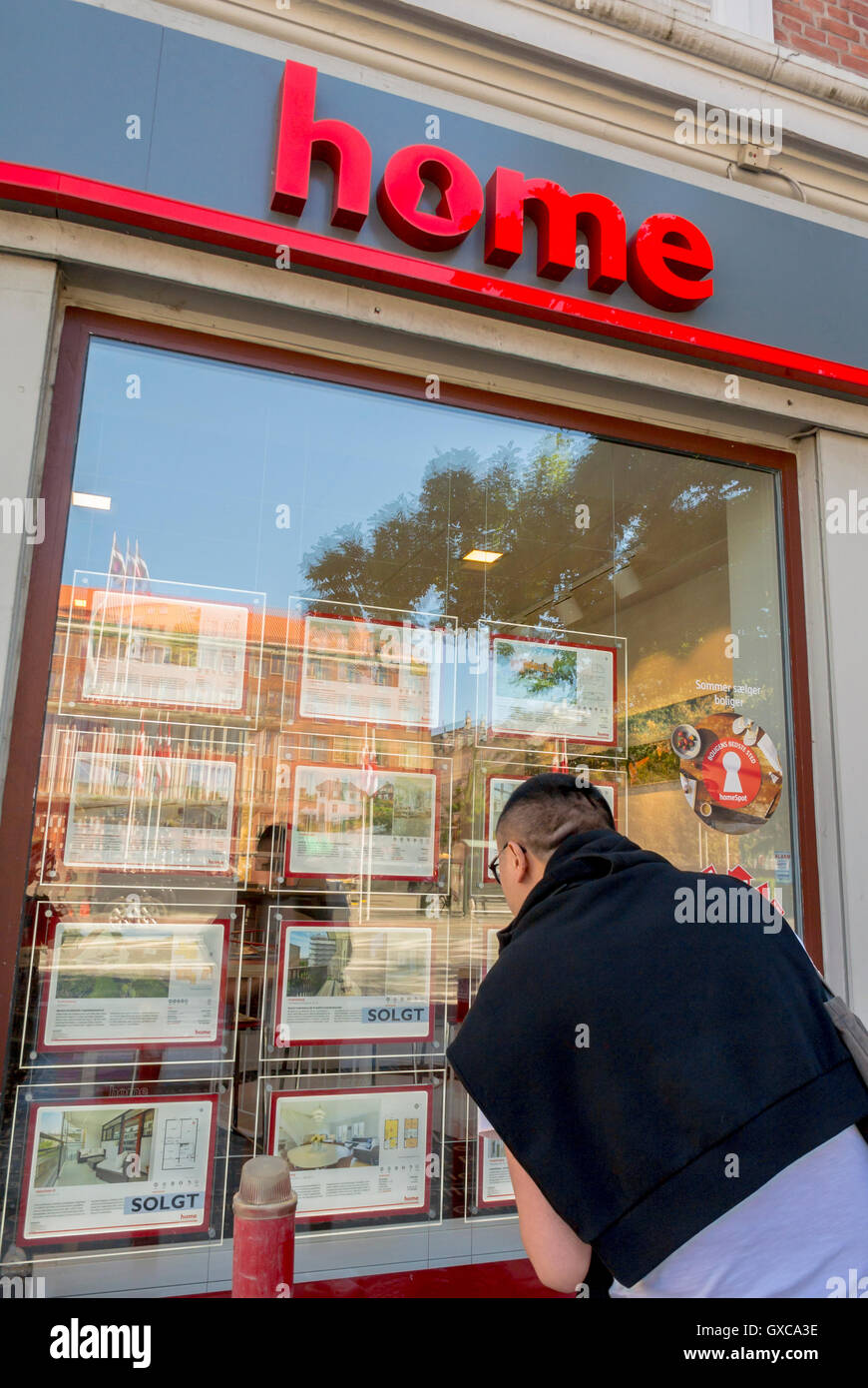 Copenhague, Danemark, Chinese Man à la recherche dans l'Immobilier La Boutique fenêtre, 'Home' Shopping, Frederiksberg Banque D'Images