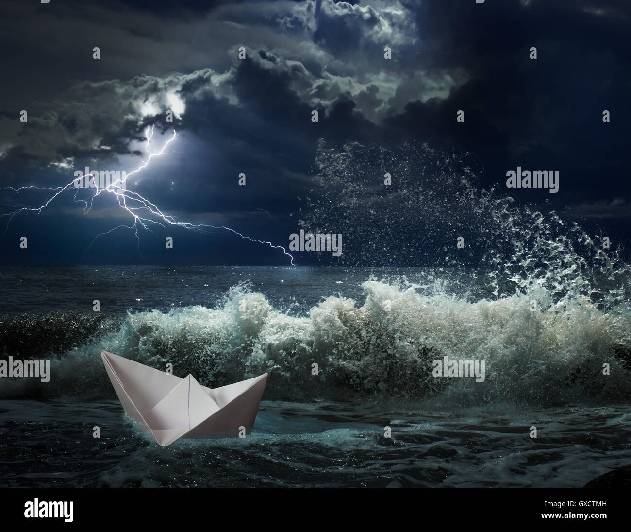 Bateau en papier lgihting avec tempête de l'océan et les vagues Banque D'Images
