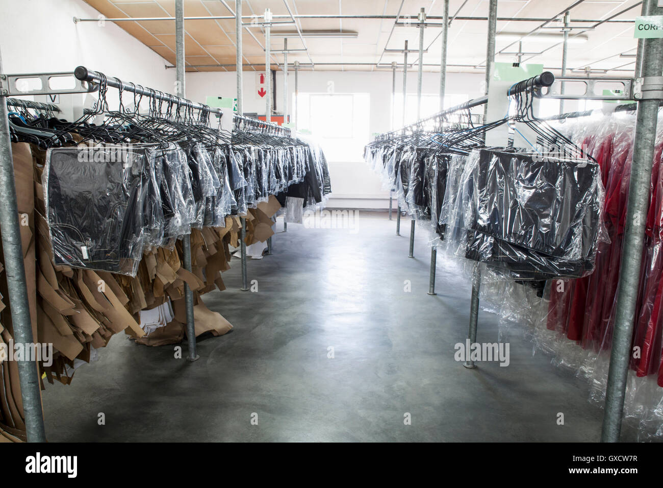 Les patrons de couture et les vêtements des vêtements suspendus sur rail dans l'usine de couture salle d'échantillons Banque D'Images