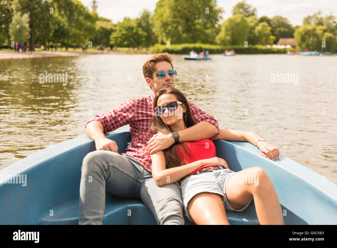 Jeune couple romantique en bateau à rames inclinables dans Regents Park, London, UK Banque D'Images