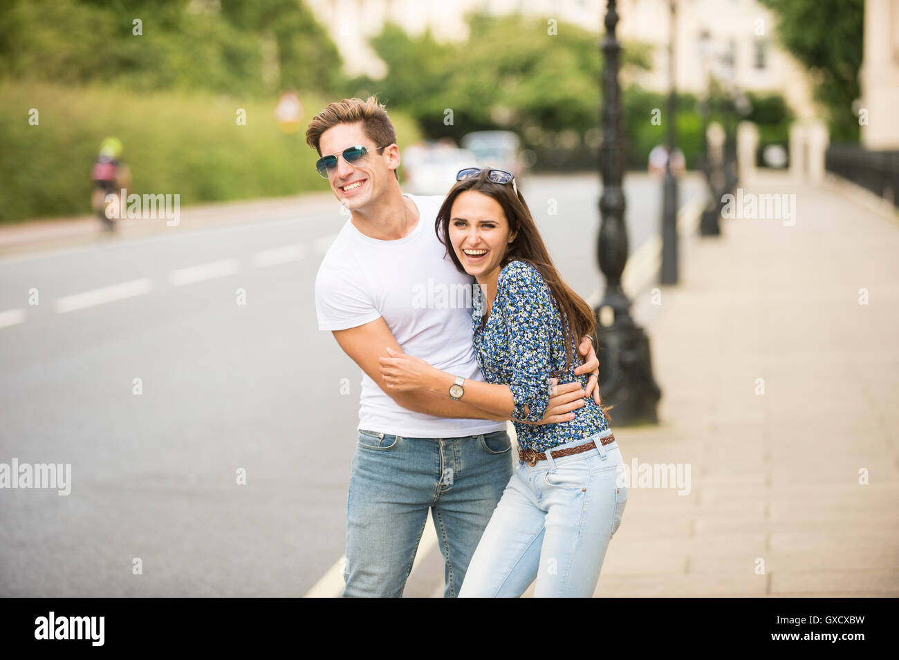 Young couple laughing on city Street, London, UK Banque D'Images