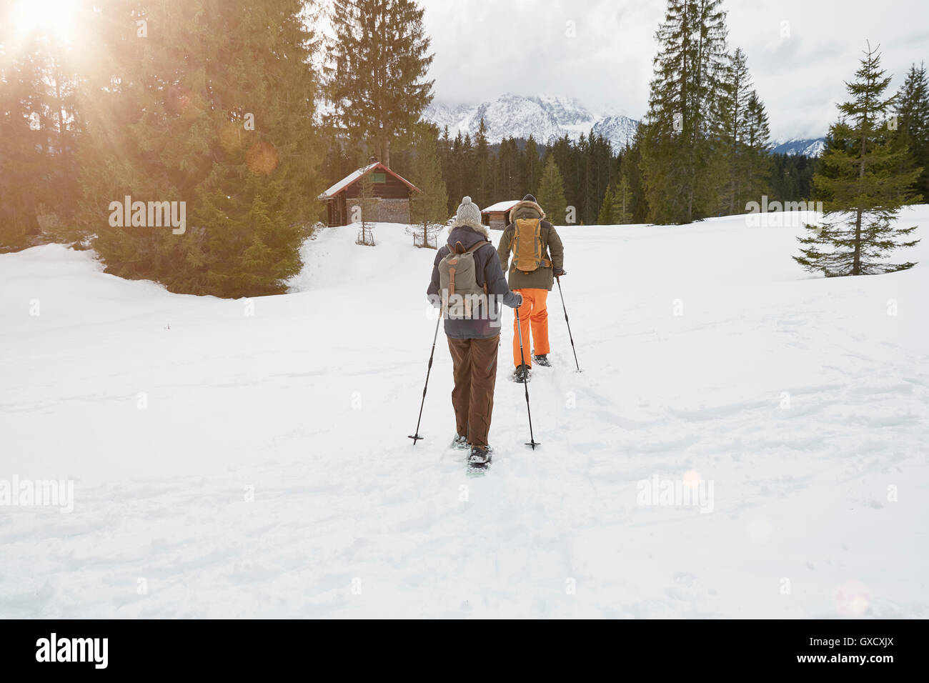 Couple snowshoeing voyage paysage enneigé, vue arrière, Elmau, Bavière, Allemagne Banque D'Images