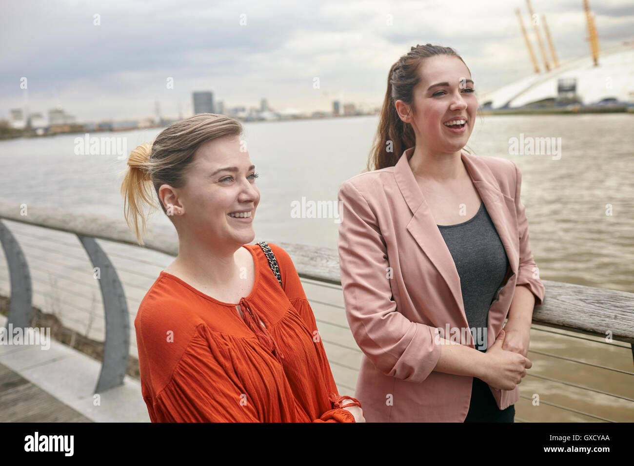 Deux jeunes businesswomen talking on waterfront, London, UK Banque D'Images