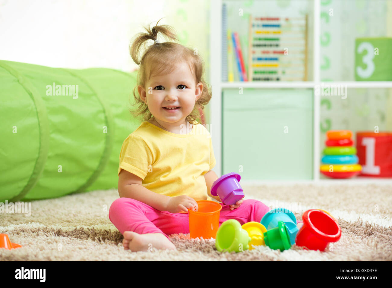 Happy kid toddler playing in nursery room Banque D'Images