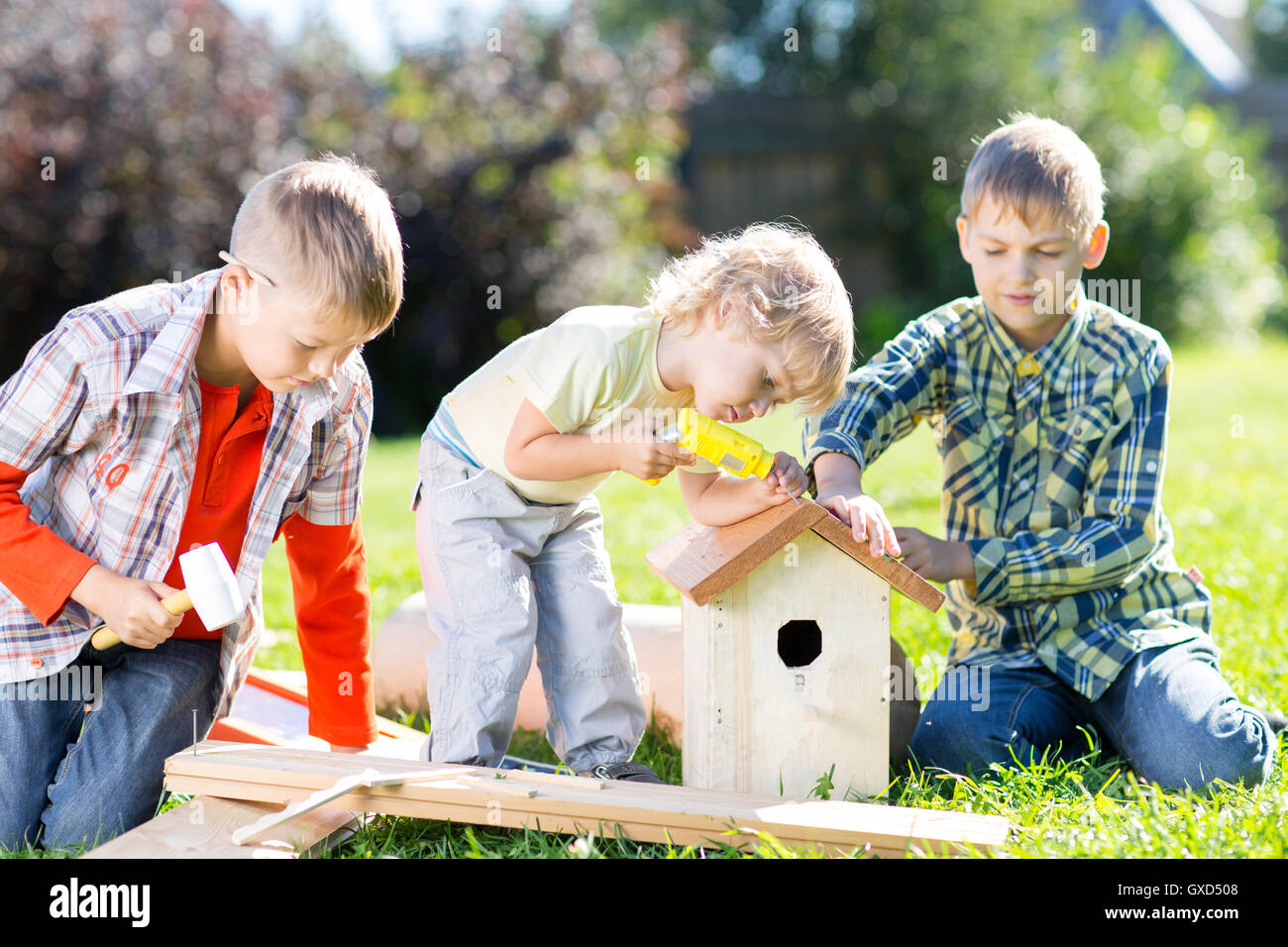 Par contre les enfants qui travaillent ensemble sur la pelouse à l'été Banque D'Images