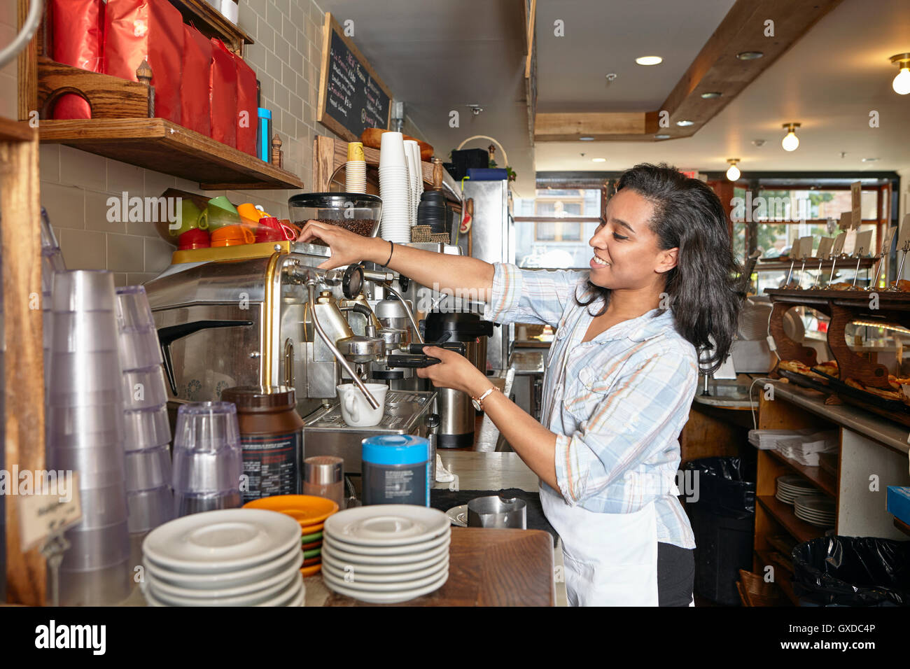 Employée dans une boulangerie, à l'aide de machine à café Banque D'Images